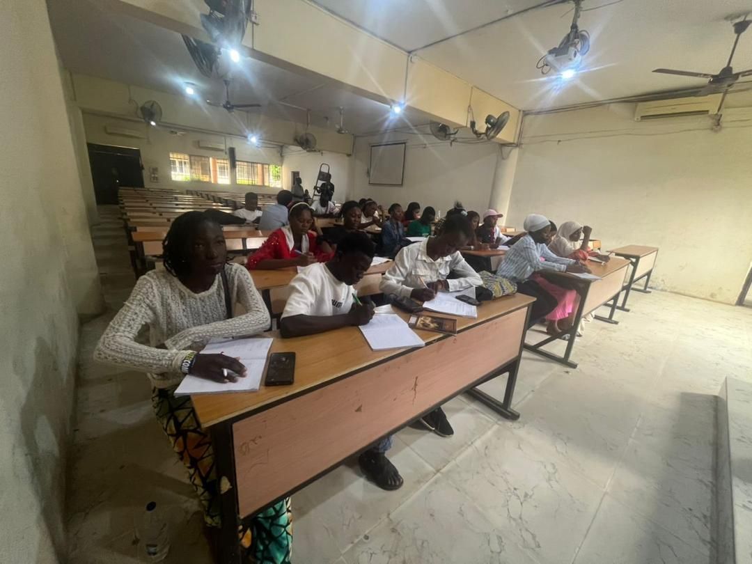 Students seated in rows in a lecture hall, writing