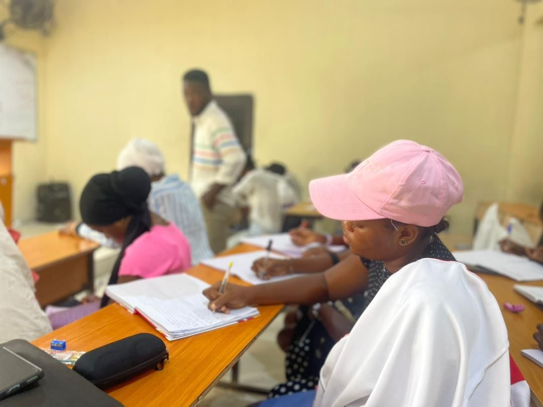 Students writing while a tutor looks on