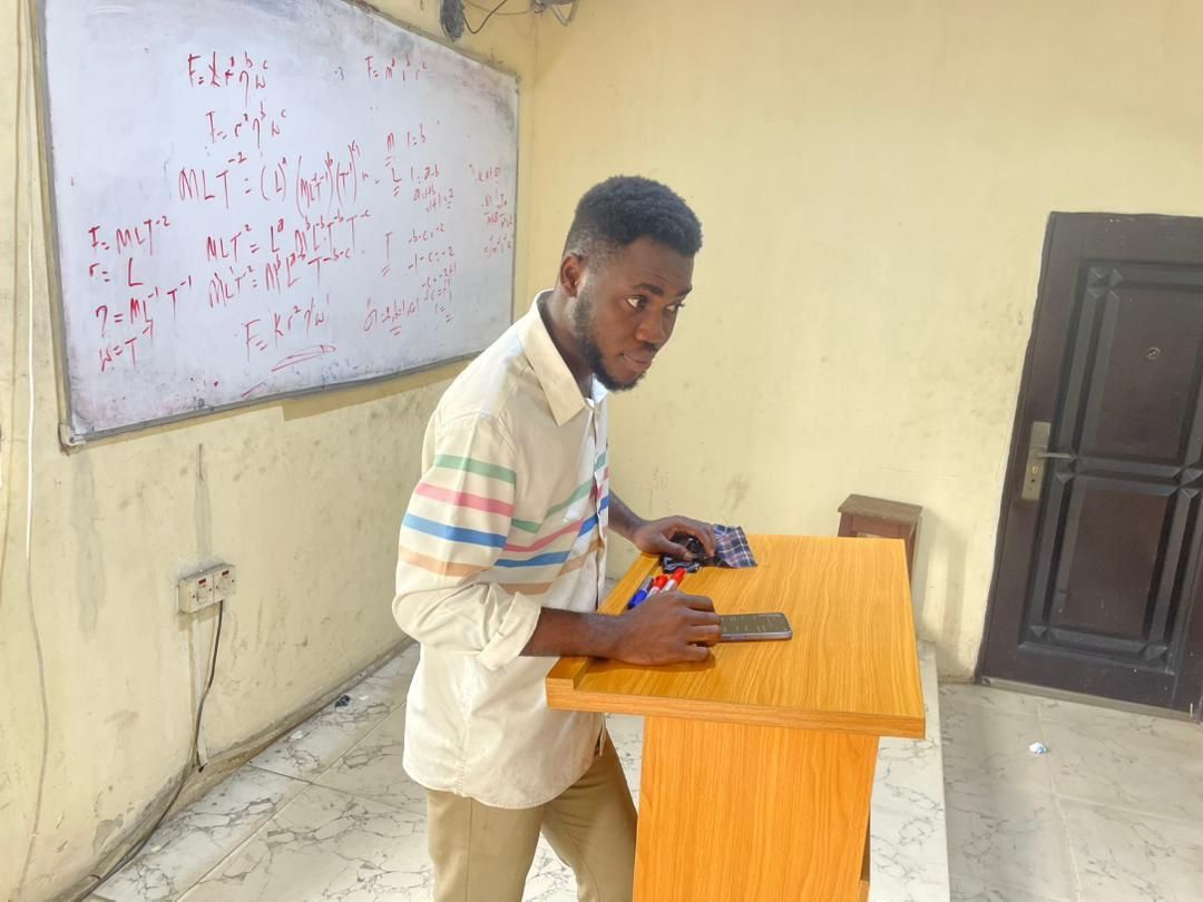 A student at a lectern in front of a whiteboard