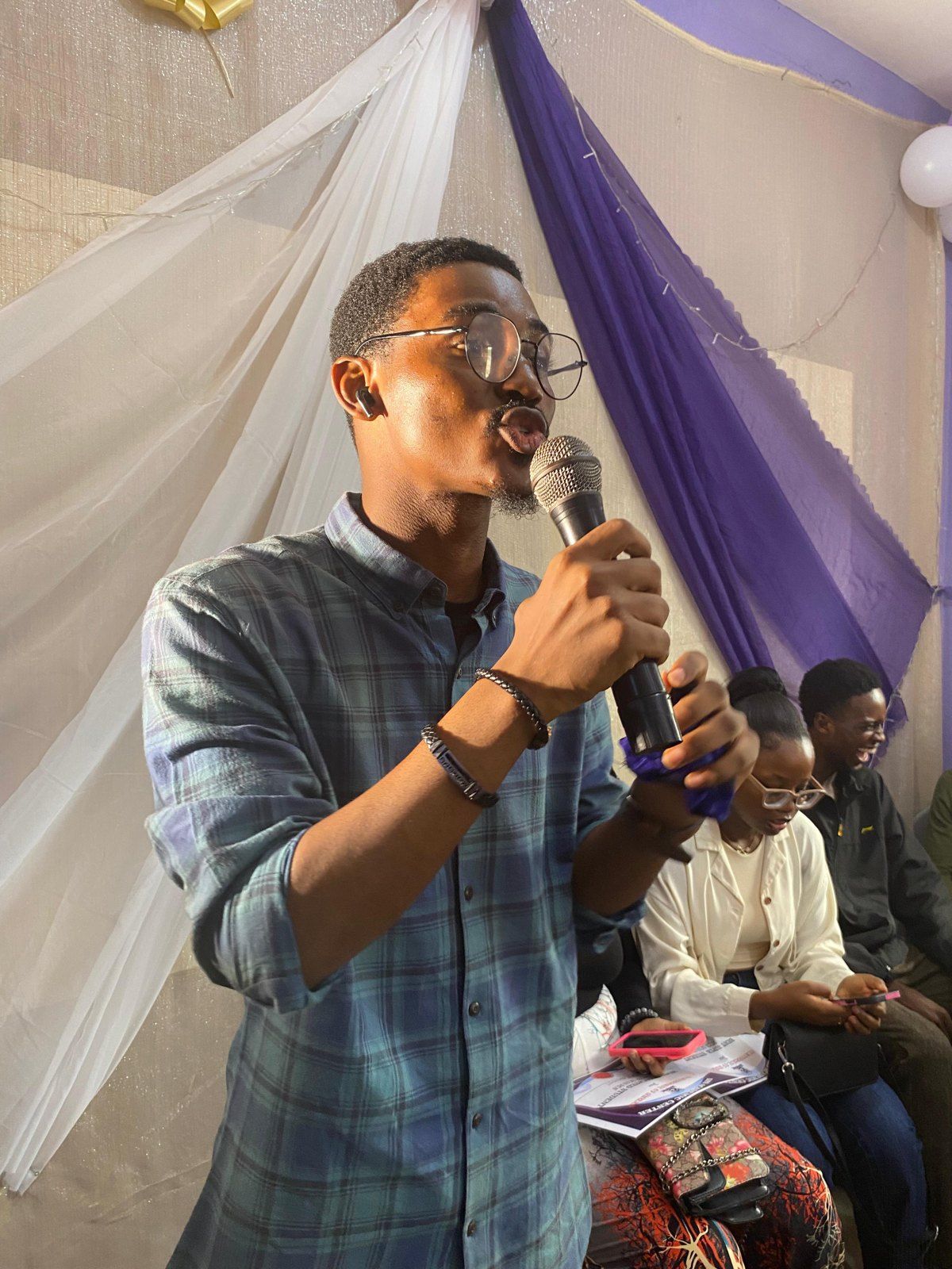Boma speaking to students with a microphone