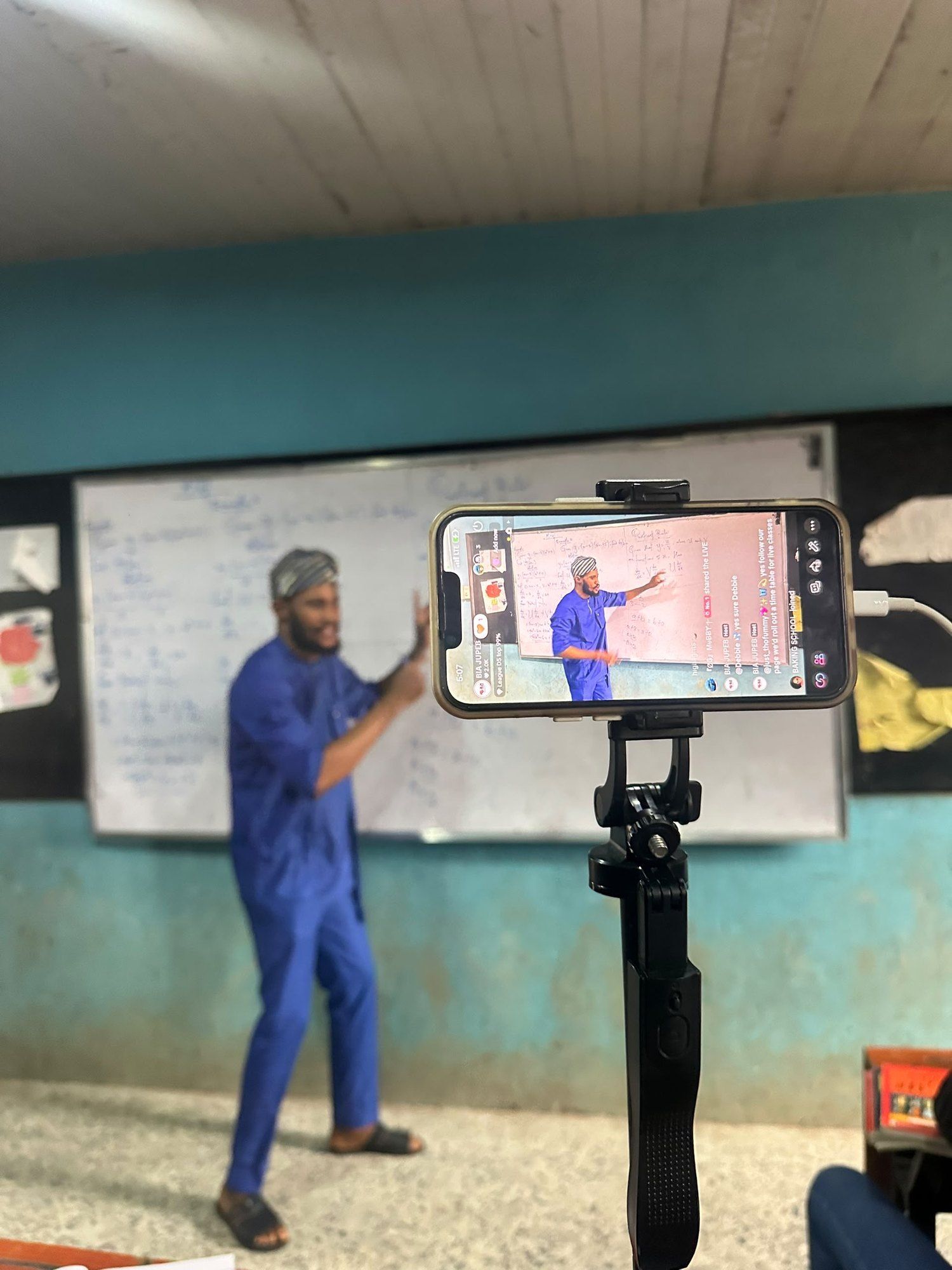 A tutor teaching in front of a phone on a tripod