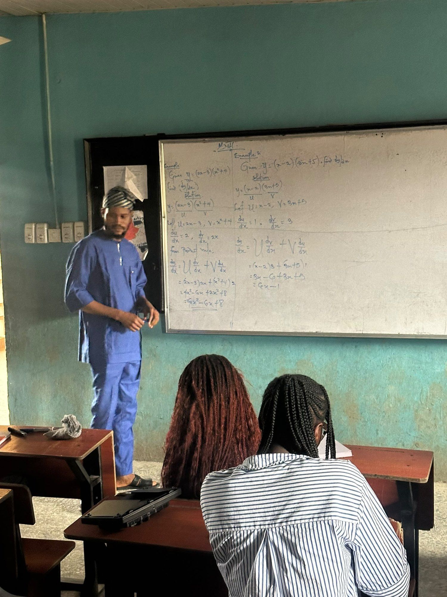 A BIA tutor teaching at the whiteboard while students follow