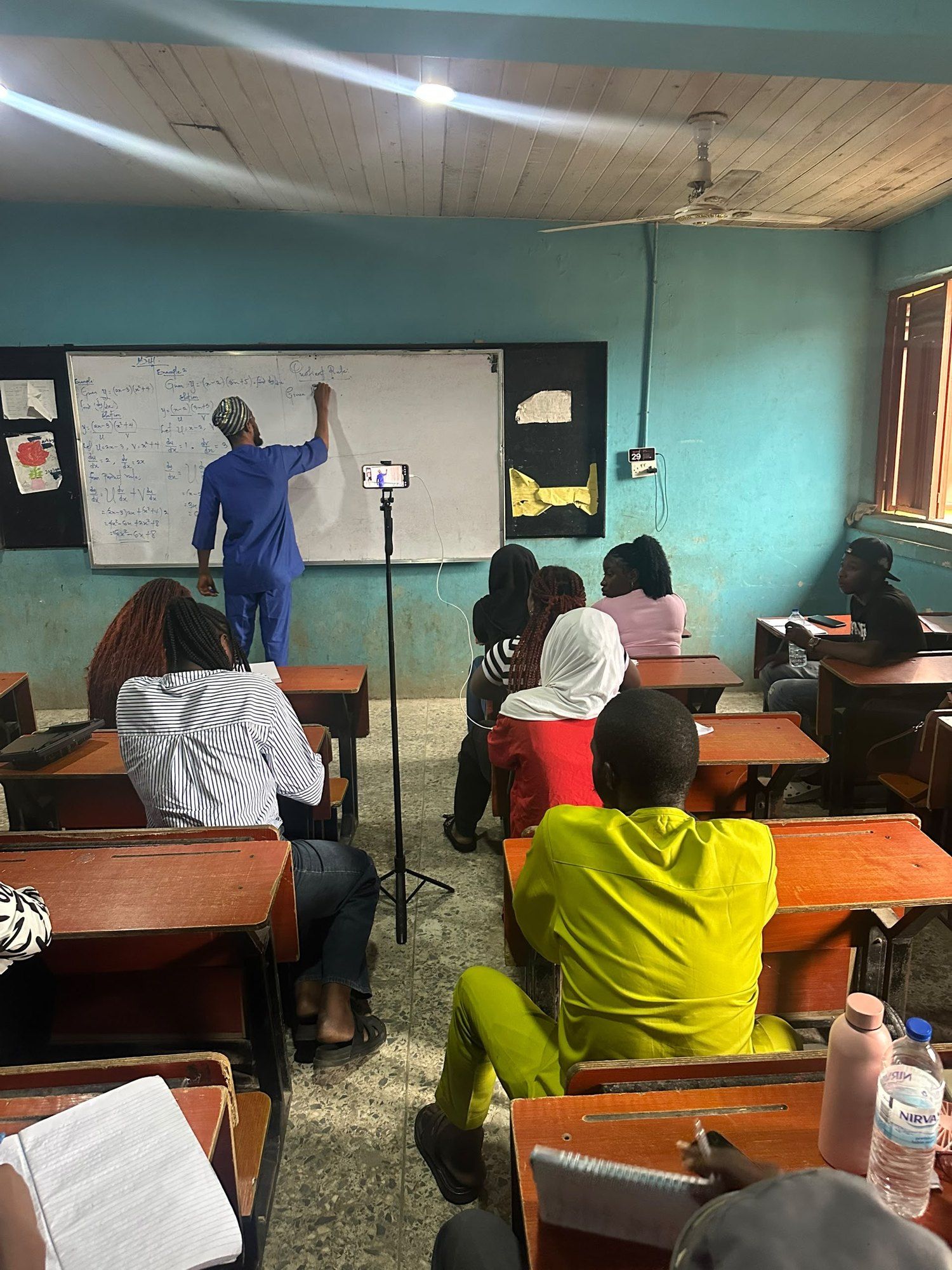 View from the back of a class as a tutor writes on the whiteboard