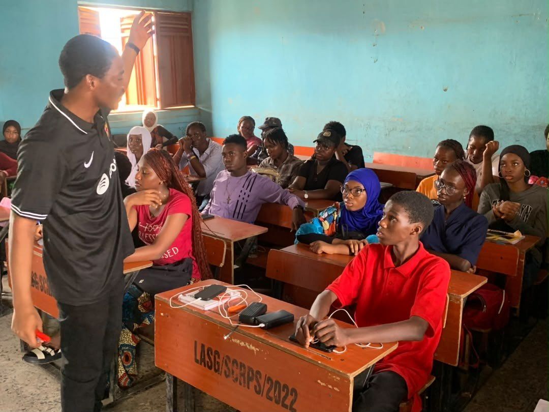 A tutor standing beside a full classroom
