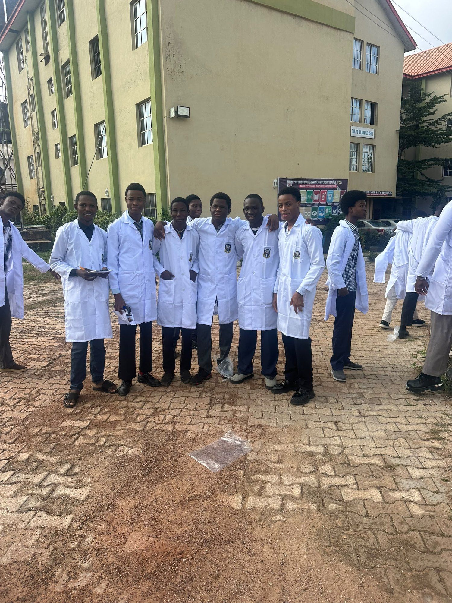 Students in white lab coats lined up outside a building